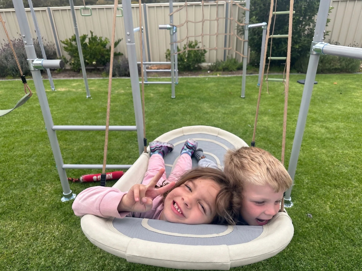 Boat Swing in use on a Growplay frame in a family garden