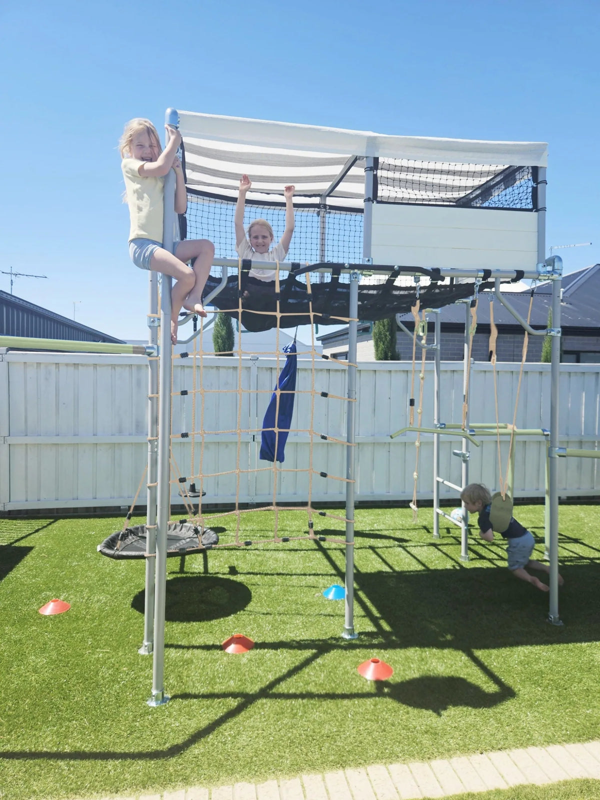 Playhouse in use on a Growplay frame in a family garden
